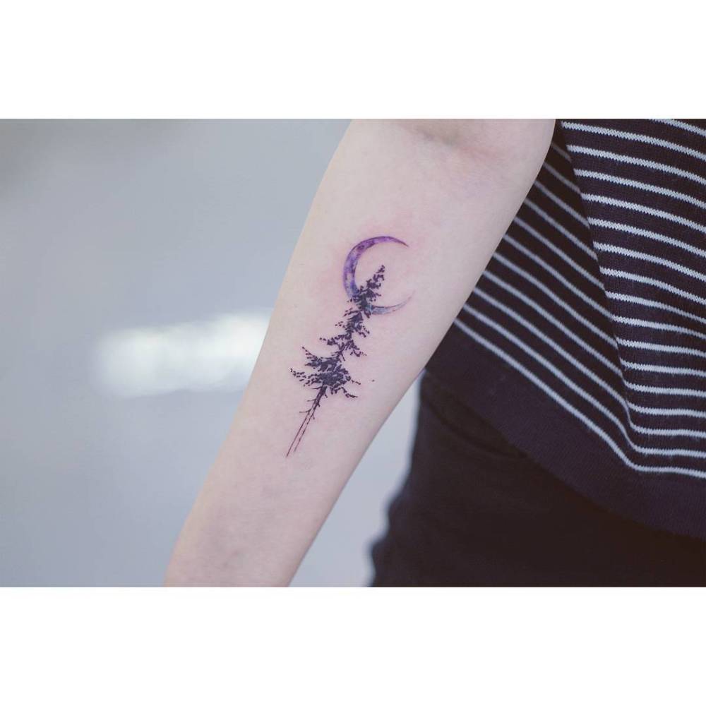 Watercolor style pine tree and moon tattoo located on the inner forearm.