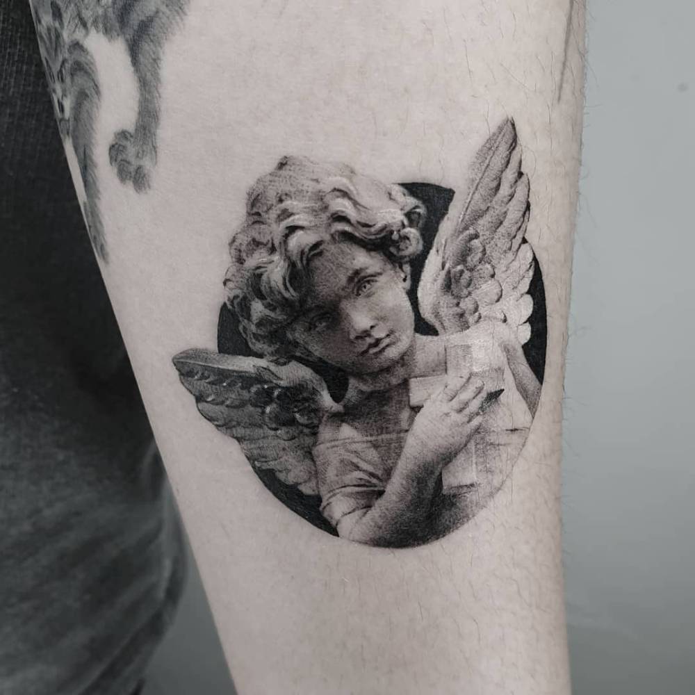 Classical style cherub portrait tattoo located on the inner forearm.