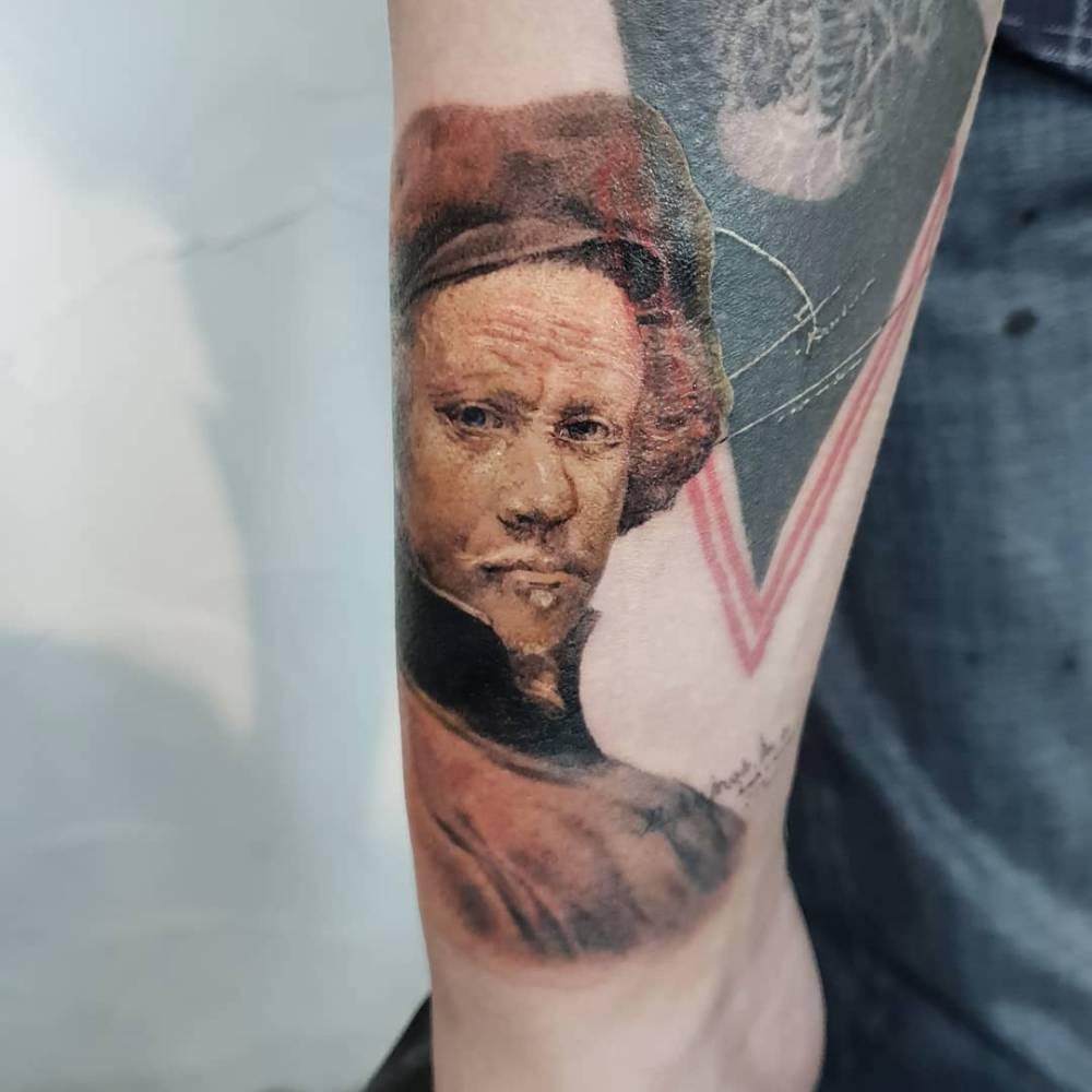 Micro-realistic style Rembrandt portrait tattoo located on the wrist.