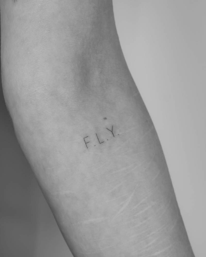 Initials tattoo located on the inner forearm.