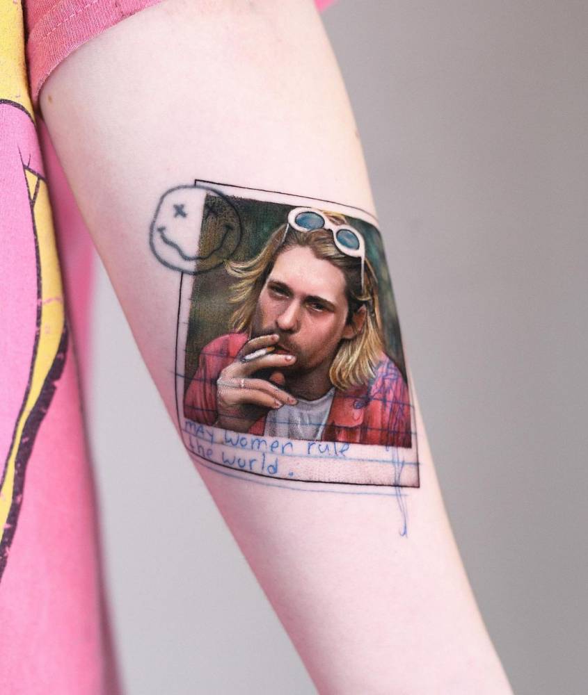 Micro-realistic Kurt Cobain portrait tattoo on the inner forearm.