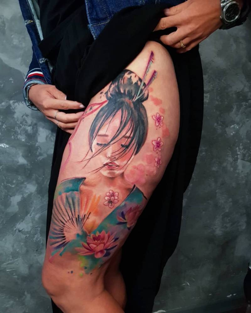 Watercolor geisha portrait tattoo on the thigh.