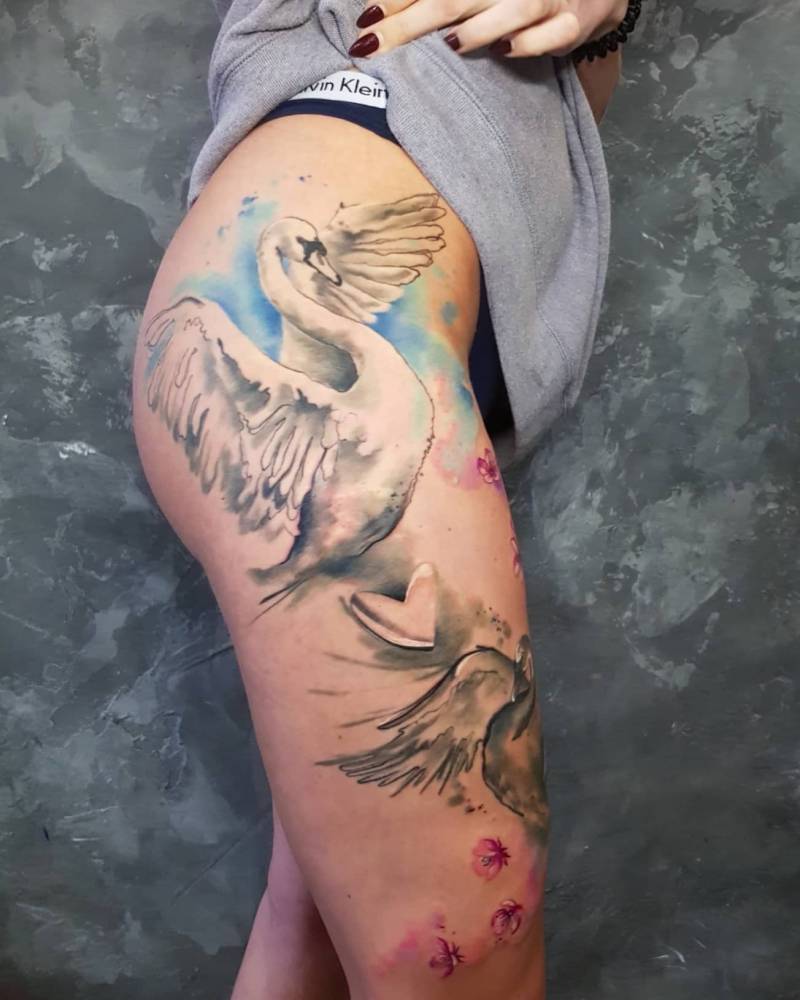 Large watercolor swan tattoo on the thigh.