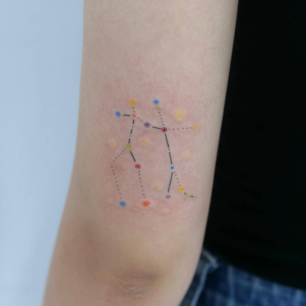 Gemini constellation tattoo in Illustrative style done on the tricep.