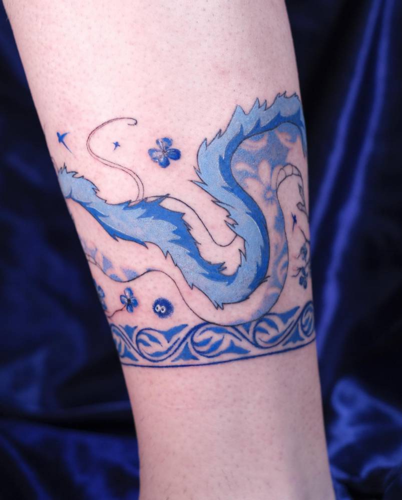 Haku leg band tattoo located on the shin, cartoon style.