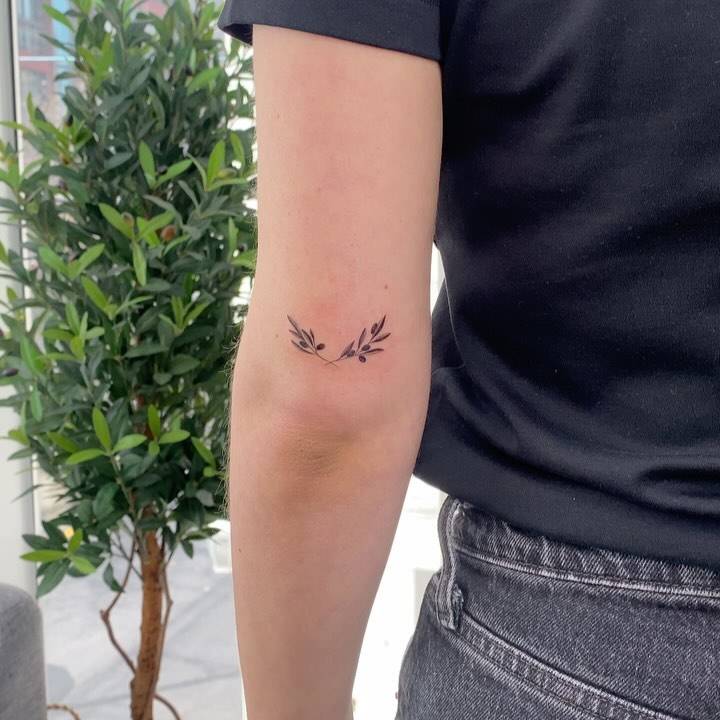 Olive wreath tattoo located on the tricep.