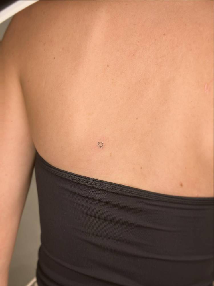 Tiny minimalistic Star of David tattoo located on the back.