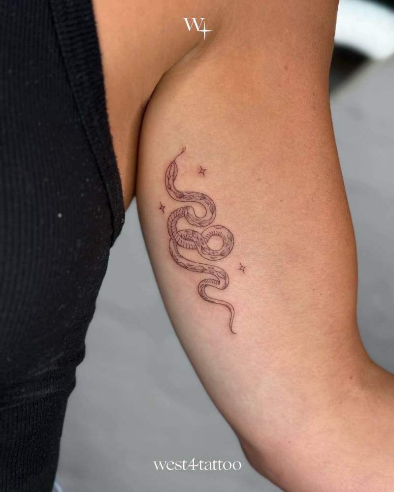 Snake tattoo in fine line style placed on the inner arm.