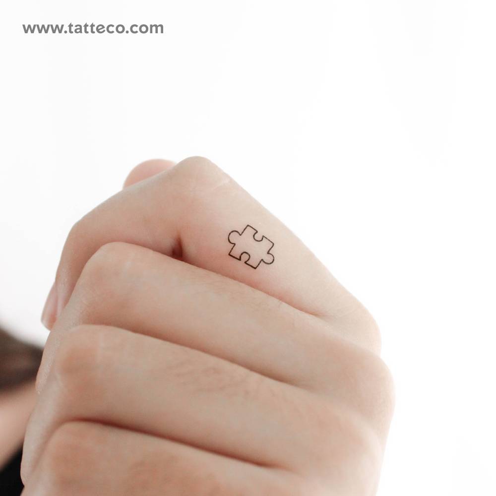 Tiny minimalistic puzzle piece temporary tattoo located on the finger.