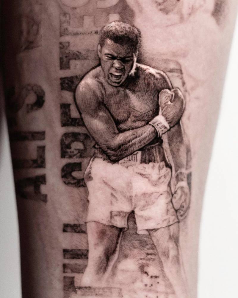 Micro-realistic Muhammad Ali tattoo on the inner forearm.