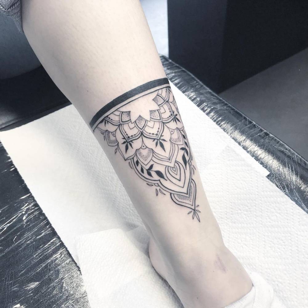 Half mandala tattoo on the shin.