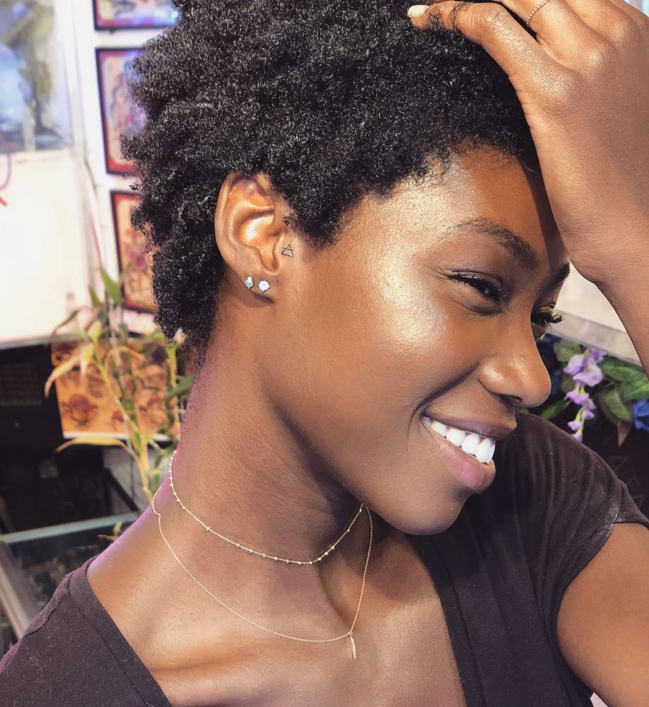 Minimalist Transcend symbol tattoo on the ear.nd