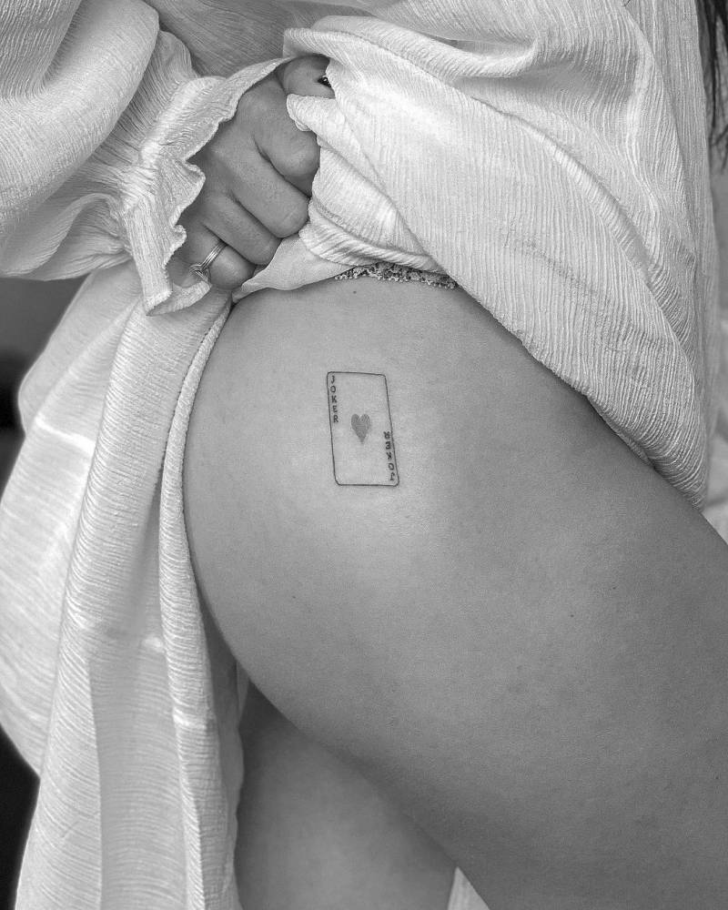 Joker card tattoo on the hip.