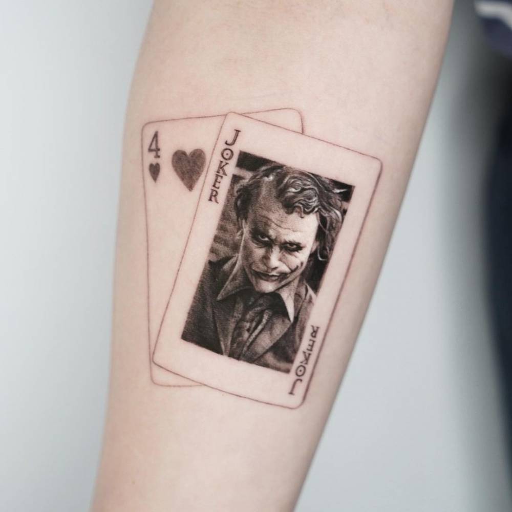Micro-realistic The Joker portrait tattoo on the inner forearm.