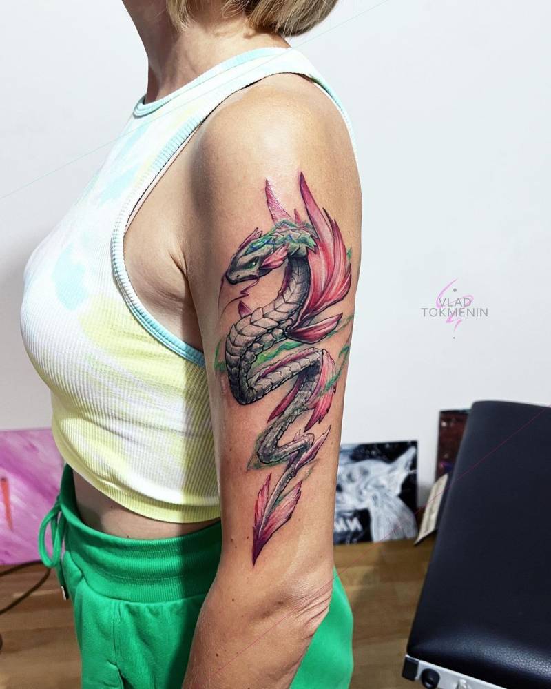 Watercolor style dragon tattoo located on the upper arm.