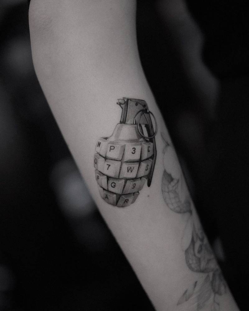 Keyboard grenade tattoo located on the forearm, micro-realistic style.