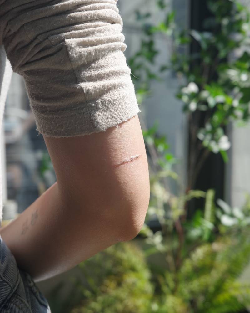 Handwritten "now" tattoo located on the tricep.