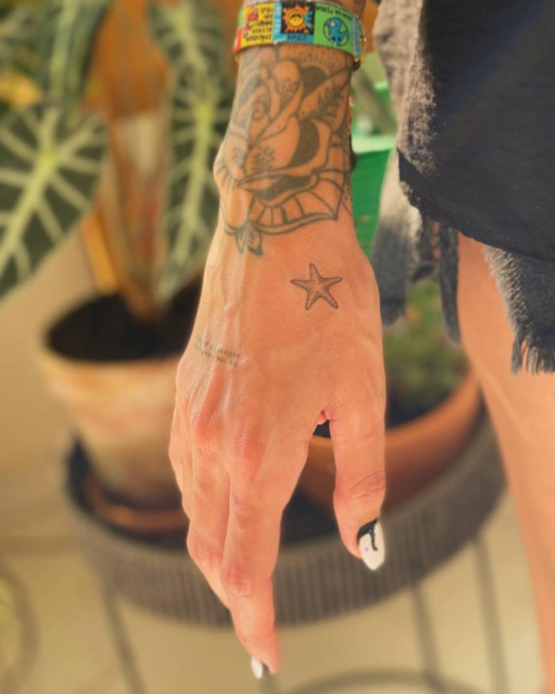 Illustrative style starfish tattoo placed on the hand.