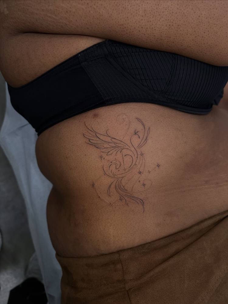 Phoenix tattoo in fine line style located on the rib.