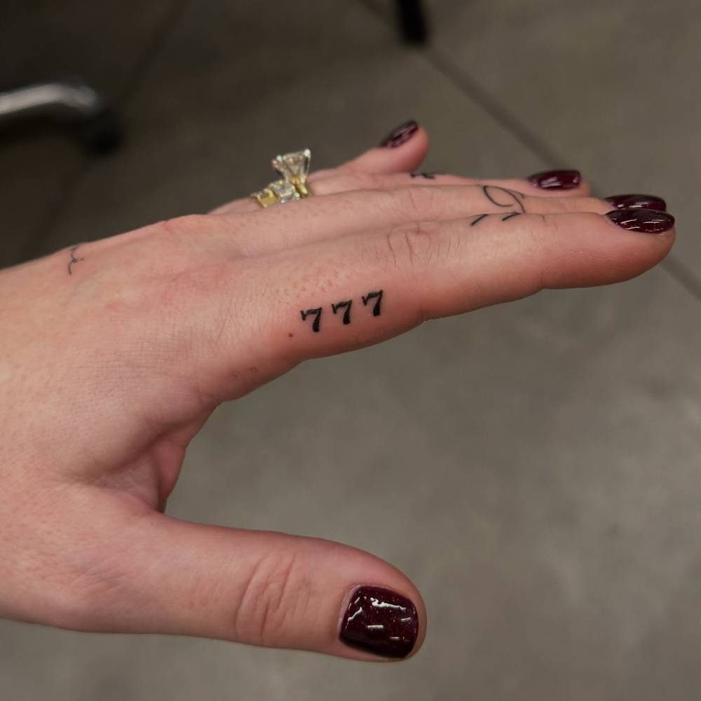 Lucky number "777" tattooed on the finger.