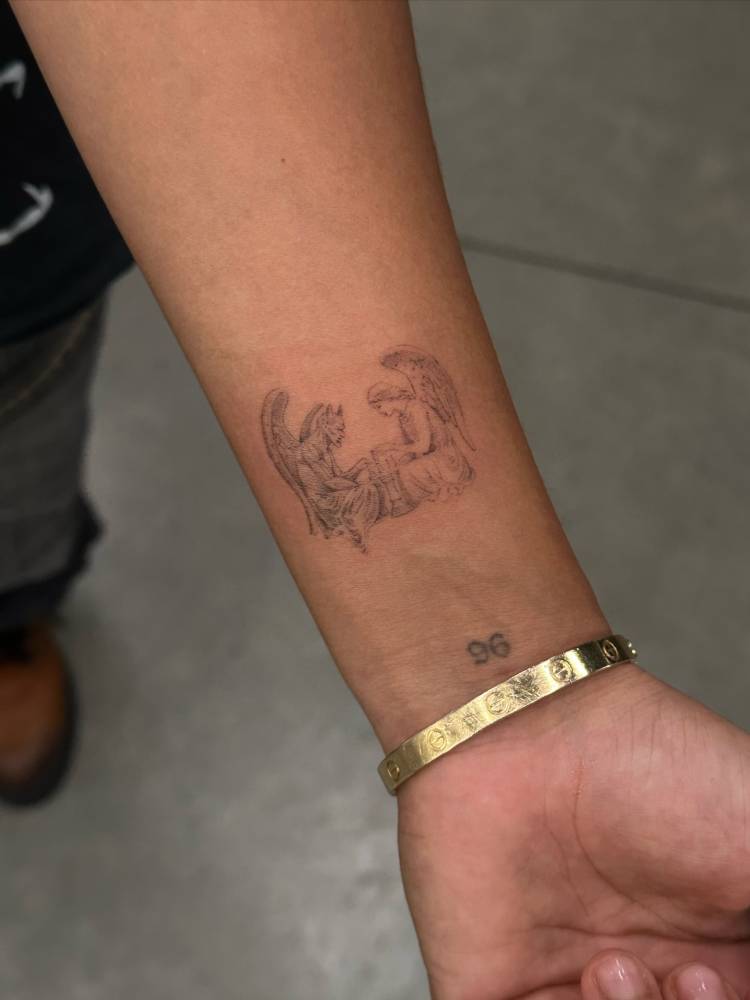Devil and angel tattoo located on the wrist.