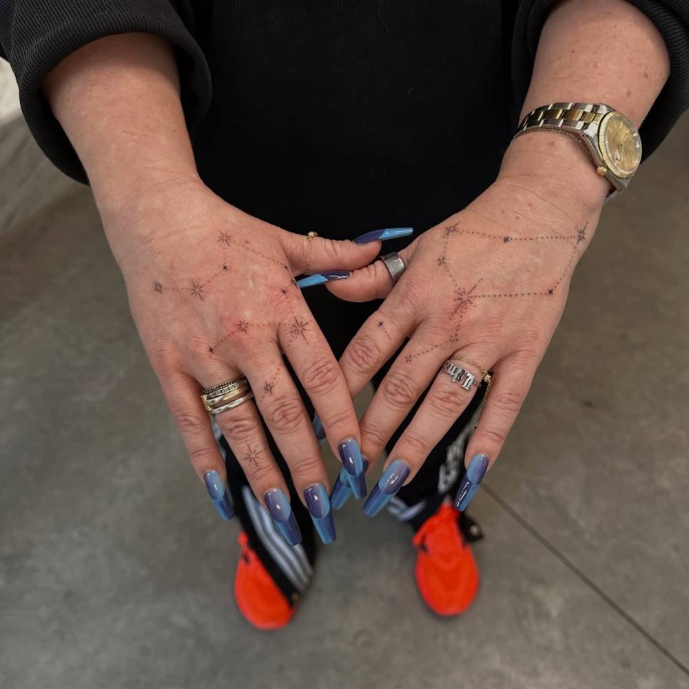 Constellations in minimalistic style tattooed on the hands.