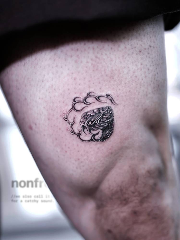 Tribal style snake tattoo located on the thigh.