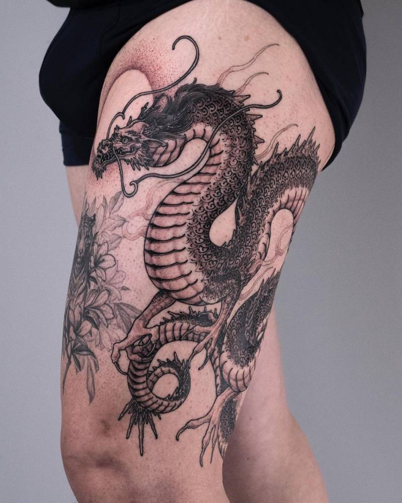 Large dragon tattoo placed on the thigh.