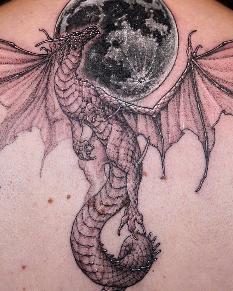Large dragon and moon tattoo located on the back.