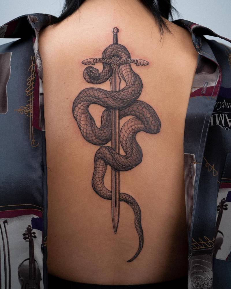 Snake and sword tattoo done on the back, blackwork style.