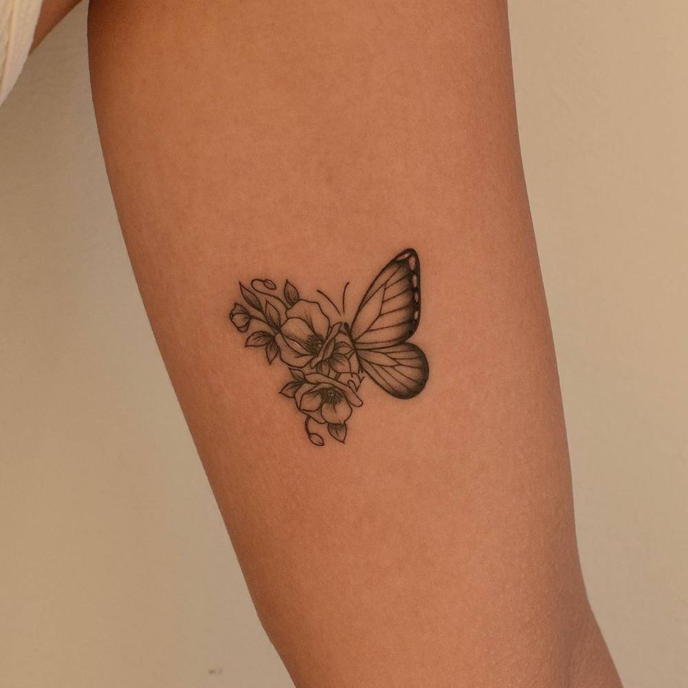 Half butterfly half flower tattoo done on the inner arm.
