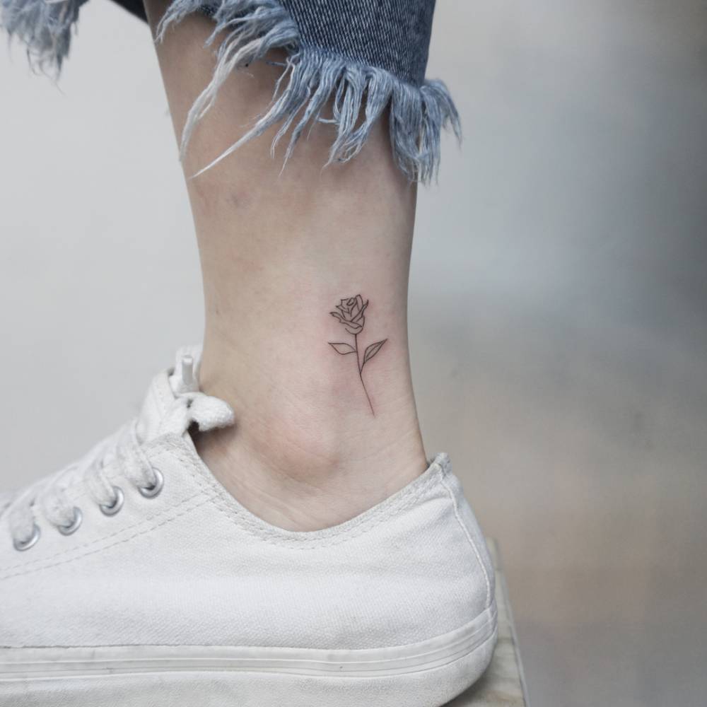 Fine line rose tattoo located on the ankle.