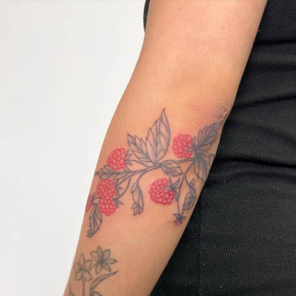 Raspberries tattoo located on the forearm, illustrative style.