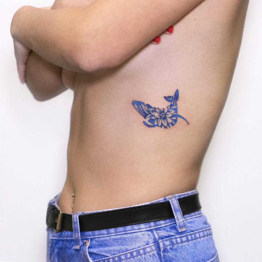 Porcelain whale tattoo located on the rib.