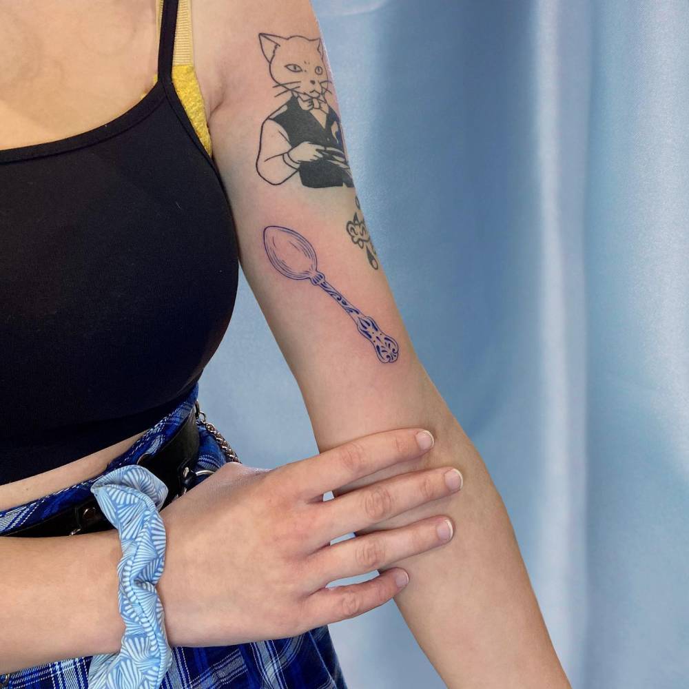 Blue porcelain spoon tattoo placed on the inner arm.