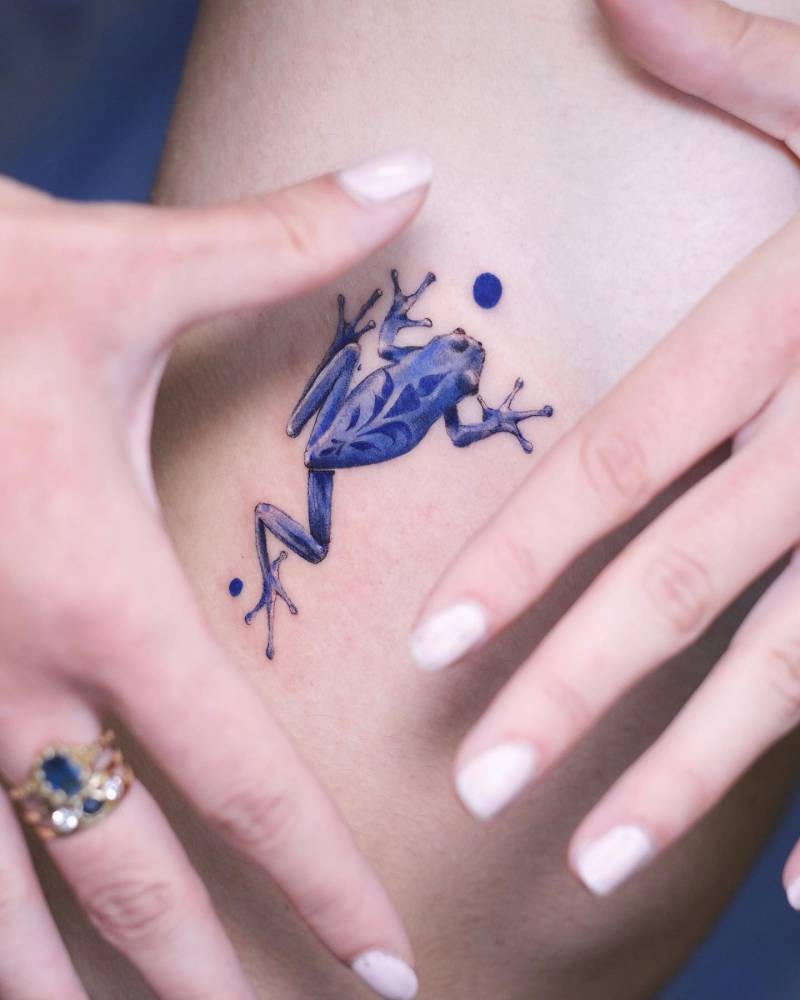 Blue porcelain frog tattoo located on the rib.