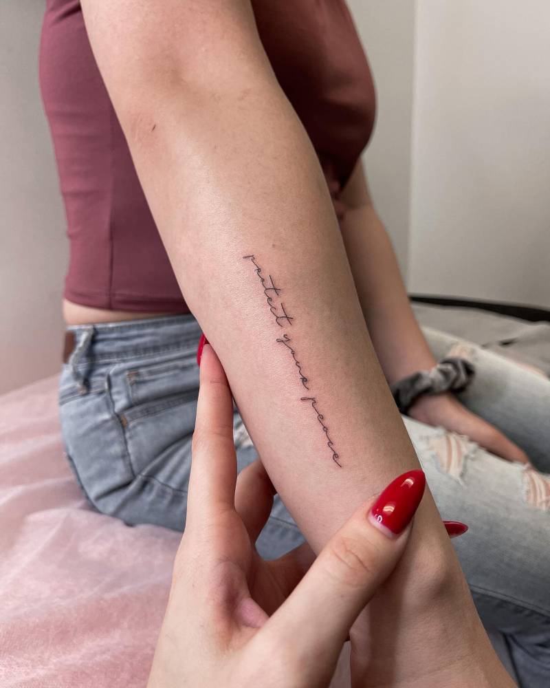 "Protect your peace" lettering tattoo handwritten on the forearm.