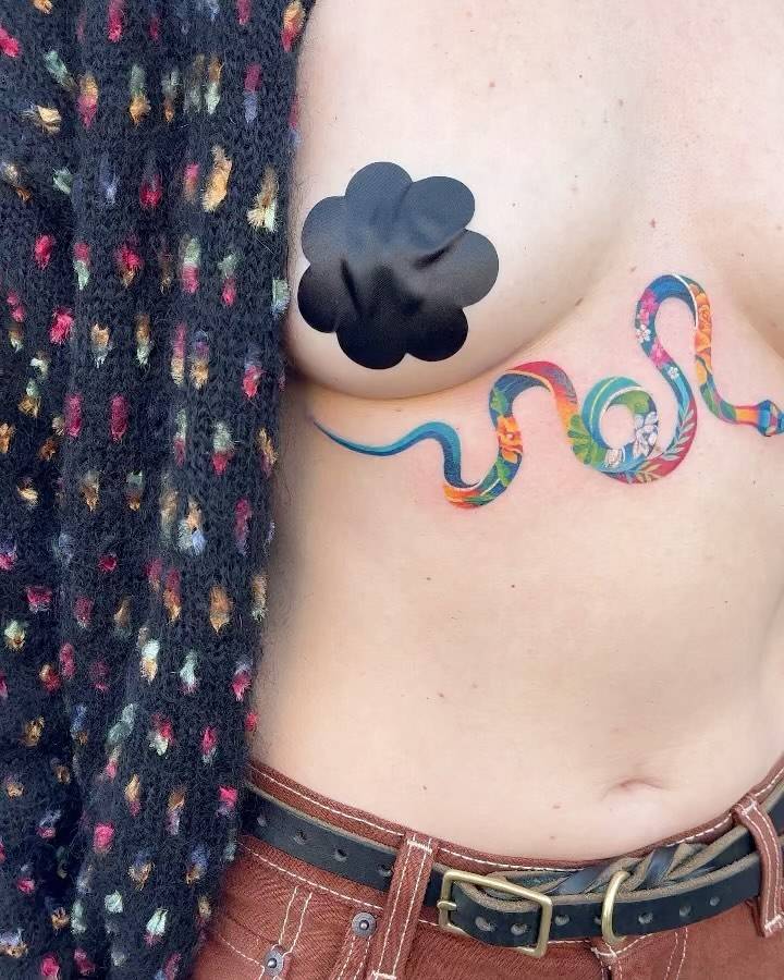 Colorful floral snake tattoo done in watercolor style.