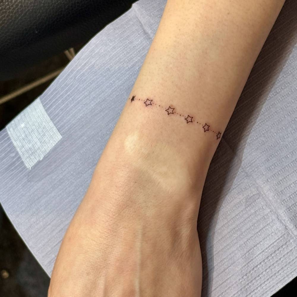 Star wristband tattoo in minimalistic style.