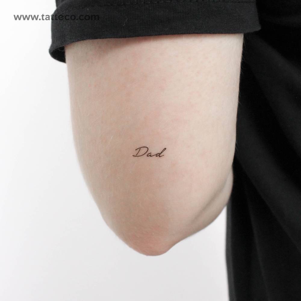 Handwritten font word "dad" temporary tattoo located on the tricep.