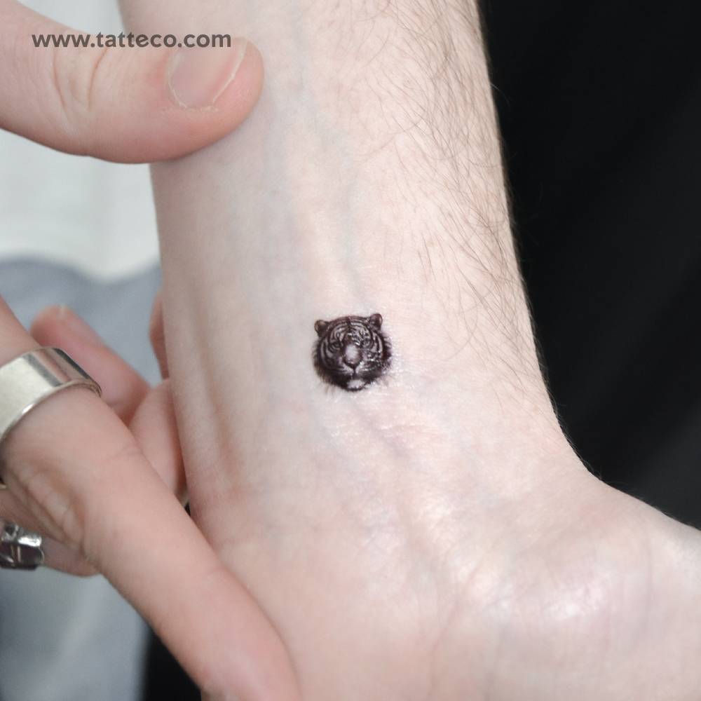 Tiny tiger portrait temporary tattoo located on the wrist.