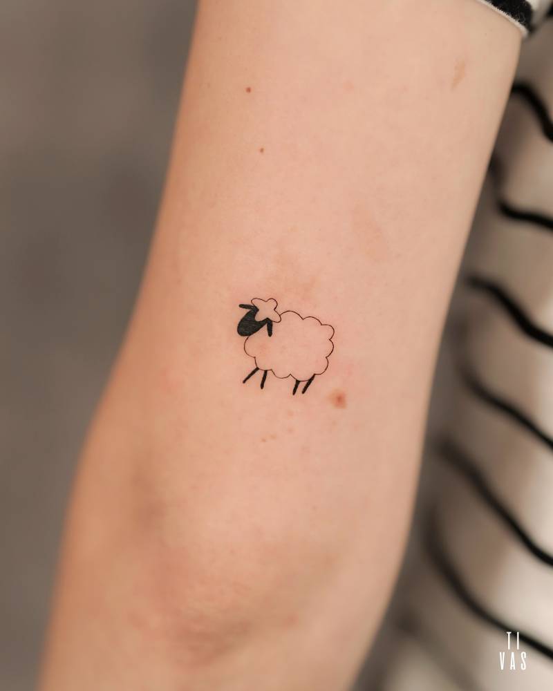 Cute minimalistic sheep tattoo located on the tricep.