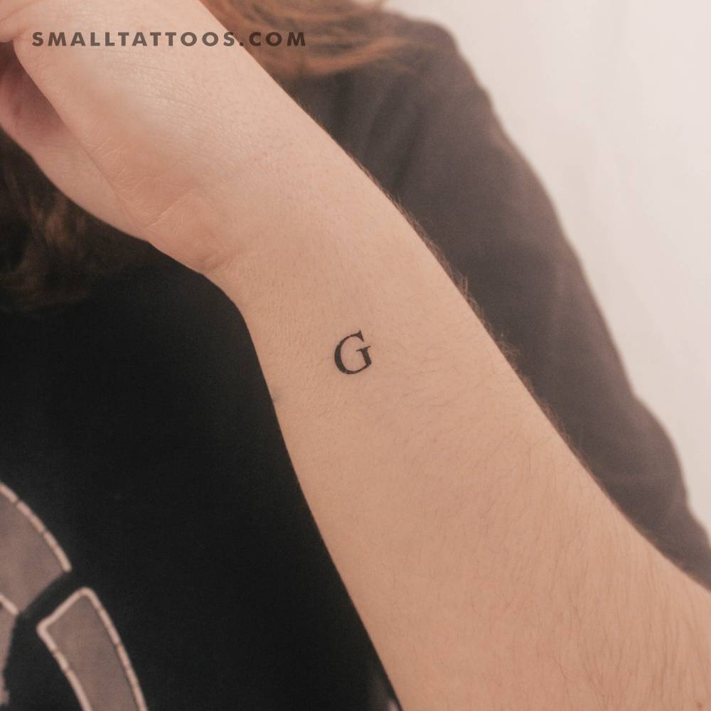 "G" uppercase serif letter temporary tattoo done on the wrist.