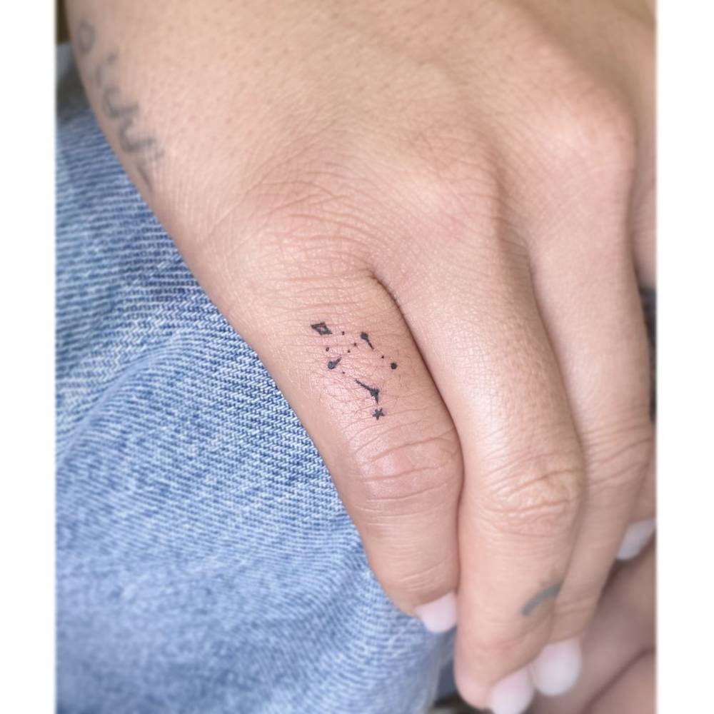 Tiny minimalistic Libra constellation tattoo placed on the finger.