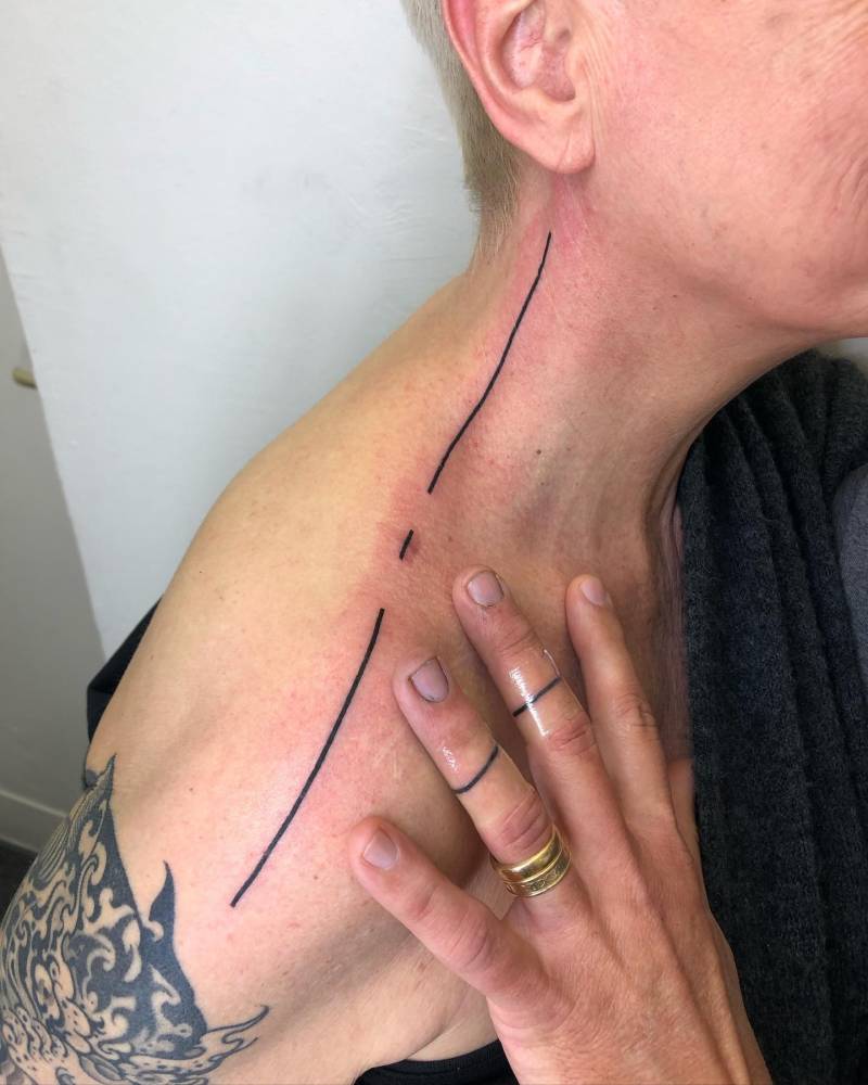 Matching minimalistic lines tattooed on couple.