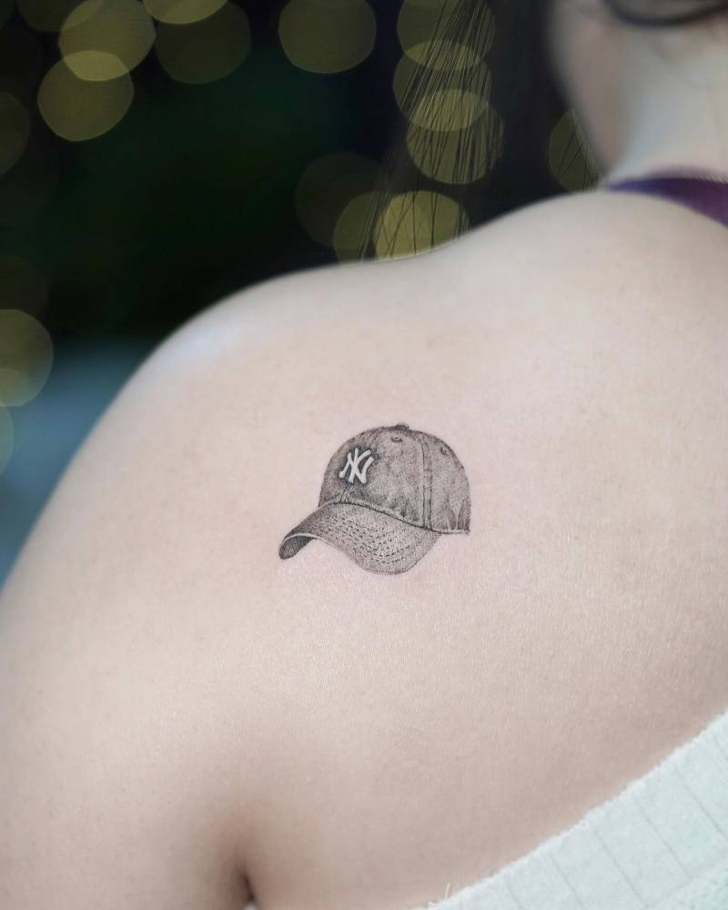 Micro-realistic NY Yankees hat tattooed on the shoulder blade.