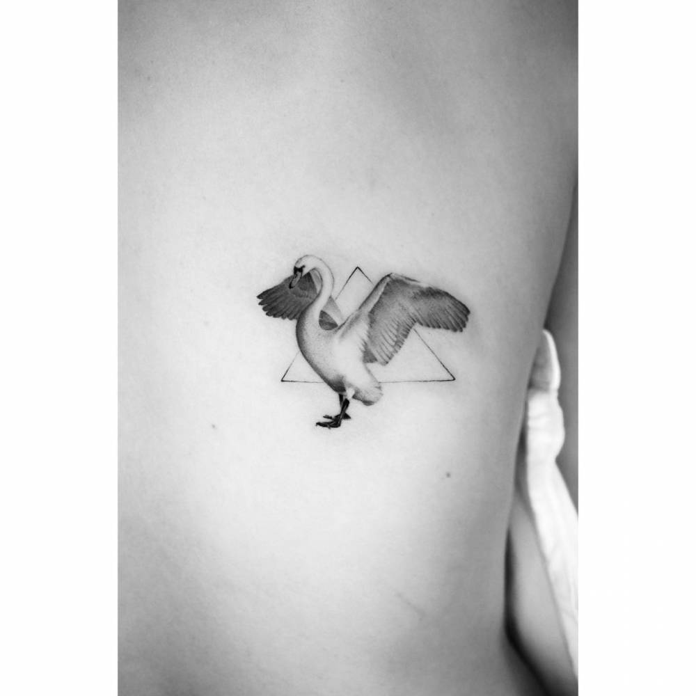Micro-realistic style swan tattoo located on the back.
