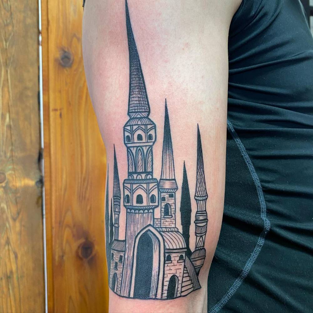 Engraving style castle tattoo located on the upper arm.