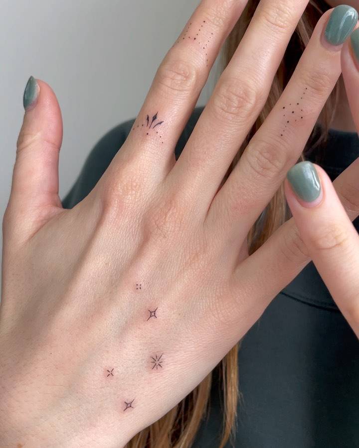 Minimalistic ornaments tattooed on the fingers.