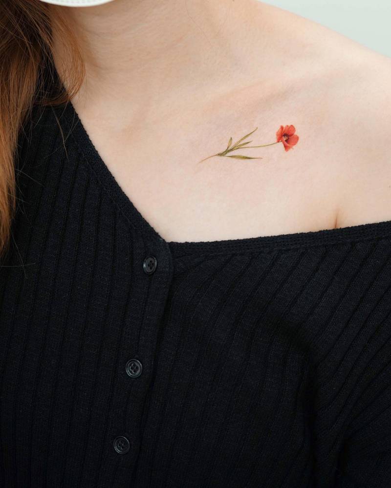 Micro-realistic simple poppy tattoo done on the collarbone.